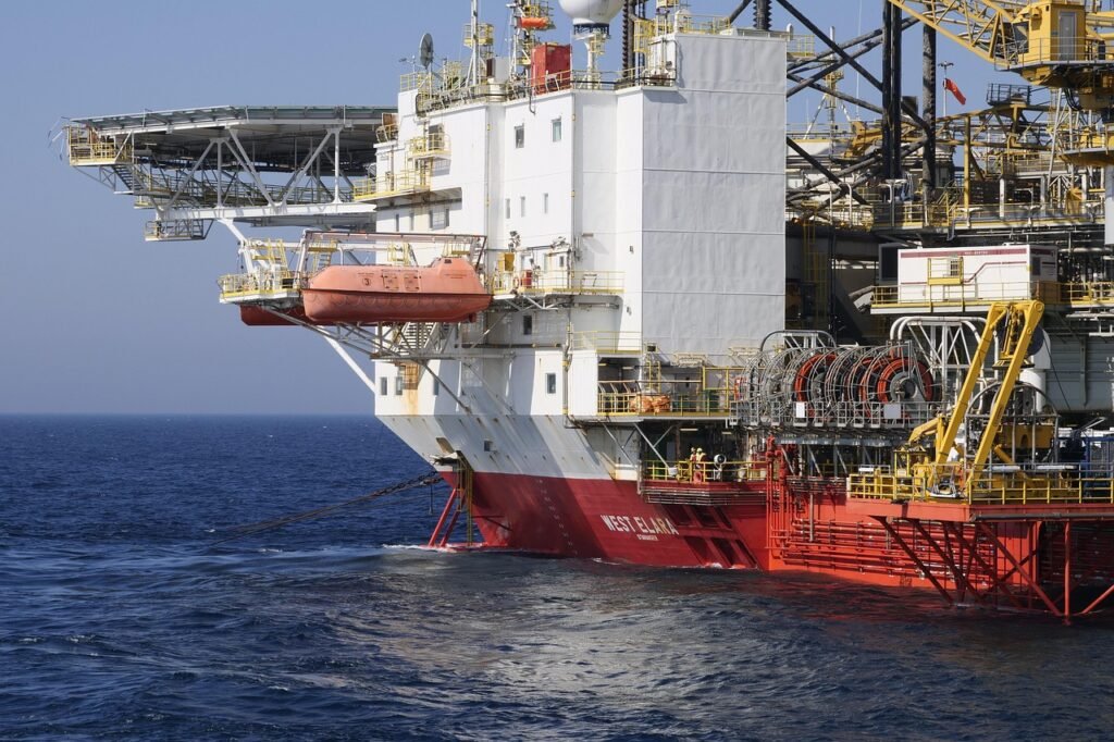 Grupo de colegas de embarque conversando no convés de uma plataforma de petróleo ao amanhecer